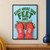Green words “START WHERE YOUR FEET ARE” above two coral paper-cut boots pointed toward a small planted patch with a flower.; frame shown for styling only