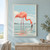 Coral-pink flamingo feeding in shallow water, with a curved neck, separated legs, ripples, and a reflection.; frame shown for styling only