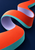 Continuous vermilion, lilac and aqua folded ribbon curling through a dark navy field to form an open central passage.
