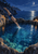 An adult swimmer dives headfirst into a blue rocky pool at night, with two glowing lanterns, a moon, and a distant sea horizon.