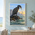 Dark long-necked seabird bends toward a small silver fish above foaming water on a rocky coastal ledge at dawn.; frame shown for styling only