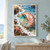 A large coral-and-rose spiral shell with a turquoise interior rests in reflective tidepool water among foam, rocks, algae, bubbles, and a partly cropped sea star.; frame shown for styling only