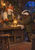 A clothed fox and badger face each other across a workbench with a glowing brass lantern between them.