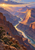 Two hikers on a rocky overlook above a winding river in a vast layered canyon at sunrise.