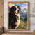 Chest-up tri-color Bernese mountain dog wearing a brass bell collar, with a blue flower, alpine meadow, lake and jagged mountains behind it.; frame shown for styling only