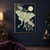 Pale mint luna moth with spread wings and long curling tails among flowering branches, with a yellow moon disk against a midnight-blue background.; frame shown for styling only