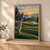 Golfer seen from behind in a high follow-through on a rolling golf course, with a small ball in the sky, distant flag, sand bunker, water, hills, and sunset.; frame shown for styling only
