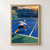 Tennis player in a white cap and shirt lunging toward a yellow ball on a blue court, with an opponent across the net.; frame shown for styling only