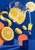 Giant tilted lemonade pitcher with lemon slices and ice, miniature cobalt-coated figure on a lemon peel and another raising a glass below.