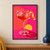 Glossy stemmed coupe with a coral-red drink, ice, bubbles and curling orange peel against a hot-pink background with coral and yellow accents.; frame shown for styling only