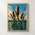 Three golden-rust cattail seed heads and crossing green leaves above teal marsh water, with a dragonfly in the bright blue sky.; frame shown for styling only
