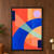 Broad cobalt arc crossing coral, apricot, and pale-mint geometric planes, with a lilac circle and two navy rectangles.; frame shown for styling only