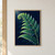 Luminous emerald and jade fern frond with a curled tip against a dark navy background, with faint shadow fronds.; frame shown for styling only