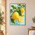 Several yellow lemons on a leafy, flowering branch, including a cut half, against a pale aqua background.; frame shown for styling only
