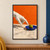 A pale sculpted-looking hand reaches toward an upright green olive on a cobalt-blue plate, with an orange wall behind it.; frame shown for styling only
