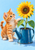 Orange tabby kitten reaching toward a large sunflower in a blue enamel watering-can planter against a pale-blue background.