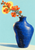 Cobalt-blue vase holding branching coral-orange blossoms against a pale-aqua background with a yellow oval accent.