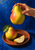 A hand holds a large ripe pear above a terracotta-colored plate with a second pear, a leaf, and a cut wedge.