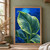 Large ribbed green leaf covered in water droplets, with supporting leaves against a saturated blue background.; frame shown for styling only