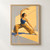 Adult dancer in a blue top and ochre wide-legged trousers holding a low side lunge in a sunlit room.; frame shown for styling only