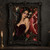 Dark-haired woman in a plum corset beside a split-open pomegranate amid flowers and dark foliage.; frame shown for styling only