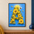 Large capital A made from yellow flowers and green leaves against blue, with a bee, loose petals and a warm glow.; frame shown for styling only