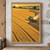 Golden combine harvester cutting a curved track through ripe grain, with dark stubble and chaff behind it beneath a tree-lined horizon.; frame shown for styling only