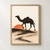 Dark one-humped camel walking along a curved sandy ridge in front of a partly obscured vermilion sun.; frame shown for styling only