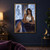 Dark-haired woman in white and deep blue seated before crystalline arched windows, with a female silhouette in the left panel.; frame shown for styling only