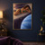 Curly-haired woman in dark green reclining on a planetary ring above a large blue planet, with another ringed planet and moons behind her.; frame shown for styling only