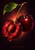 One cut-open red cherry with a prominent pit and one whole cherry on connected stems, with a green leaf against a dark background.