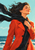 Adult woman with dark windblown curls in an orange-red coat holding a long black scarf against an aqua sky and dark teal sea.