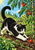 Black-and-white cat crouching in a sunny tomato garden and reaching toward a red tomato, surrounded by green vines and foliage.