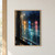 Rain droplets on a dark-framed window catch blurred amber, blue and rose city lights above a smoky teal reflection.; frame shown for styling only
