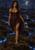 Barefoot woman in a burgundy dress walking through a moonlit bog with blue glowing lines across the ground and a dark forest behind.