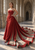 Woman in a strapless red gown poses in a stone cathedral with the long train spread across the tiled floor.