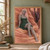 Pink-haired, pointed-eared woman in a dark green dress seated barefoot against layered red sandstone.; frame shown for styling only