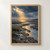A winding reflective channel crosses a dark wetland beneath storm clouds, with golden sunlight on the water and small birds flying near the horizon.; frame shown for styling only