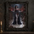 Pointed-eared woman in a dark embroidered outfit holding a red thorny crystalline branch in a dim workshop aisle.; frame shown for styling only