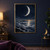 Large bright crescent moon above layered silver clouds, with a dark mountain ridge, reflective cloud path, and rocky foreground.; frame shown for styling only