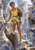 Woman in yellow and turquoise climbing among giant broken blue-and-white pottery while carrying a decorated vessel.