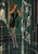 Full-length woman in a black-and-emerald geometric outfit beside tall faceted reflective panels showing repeated corridors and arches.
