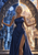 Braided woman in a blue gown framed by a circular arch between a blue nighttime city and a warm sunlit city, with moon and sun motifs.