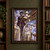 A pointed-eared woman in ornate purple clothing walks through a gilded library holding an open book as pale spider-like pages fly around her.; frame shown for styling only