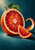 Large ruby-orange blood orange cut cross-section with a green leaf, leaning wedge, and curling peel on a dark teal ground.