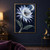 A large pale blue-white flower with a moth at its dark center, crescent moon, stars, and diagonal green leaves on a midnight-blue background.; frame shown for styling only