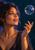 Portrait of a woman watching an iridescent soap bubble above her raised hand against a deep teal background.