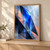 A luminous cobalt angular shard runs through overlapping pale, midnight-blue, and pale coral geometric facets.; frame shown for styling only