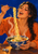 Smiling woman in an orange garment lifting noodles with chopsticks above a decorated ramen bowl on a wooden tabletop.