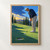 Golfer in a white cap and navy top bends over a putter on a sunlit green near a ball and cup, with cypress trees and hills beyond.; frame shown for styling only